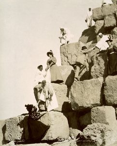 Touristes montant les pyramides avec des guides locaux